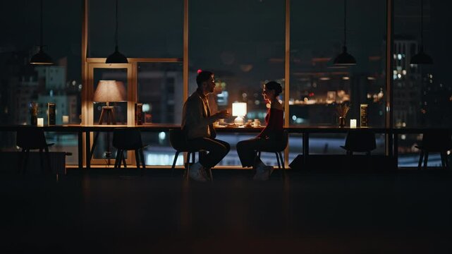 Married pair enjoying date in cozy dark restaurant. Boyfriend talking girlfriend