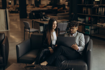 Obraz premium Business Professionals Collaborating on a Laptop in a Modern Office Setting