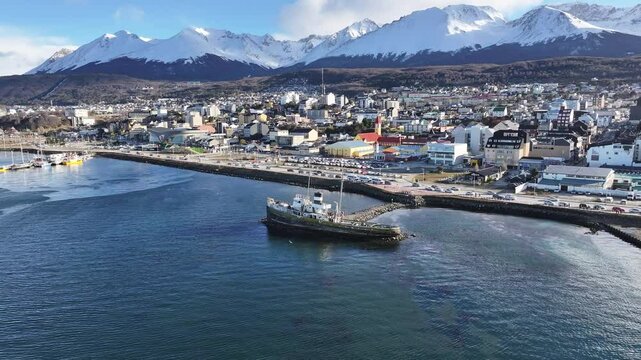 Saint Christopher Boat In Ushuaia Tierra Del Fuego Argentina. Turquoise Ocean Waves Gently Crashing On Tropical Beach. Nature Travel Destinations Snow Covered Forest Trees.