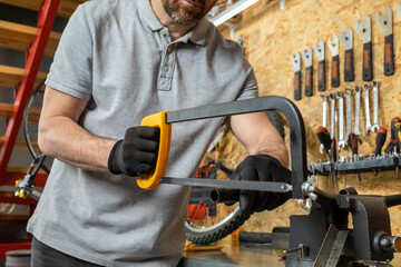 Mechanic using hacksaw