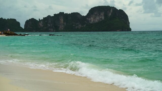 Beach shore against turquoise water and islands on the horizon