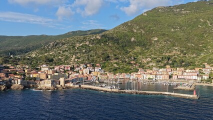 Il porto e il borgo marinaro dell'Isola del Giglio, Toscana, Italia. 
Veduta aerea del paesino che...