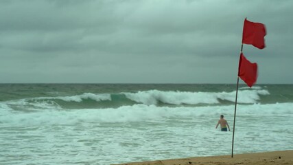 Amid red flags, a man went swimming in a dangerous ocean with big waves