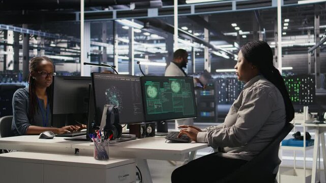 Scared data center technicians reacting to virus warning on PC display, scrambling to launch emergency response protocol. Admins run around server room, urgently trying to fix hacked systems, camera A