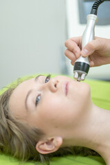 Caucasian woman undergoing radio wave RF lifting procedure in beauty salon. 