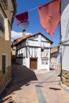 Medieval decorations hanging over narrow street in Canete, Spain