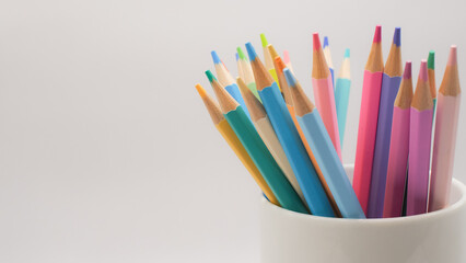 The colored pencils arranged in a white cup evoke a sense of potential with negative space emphasize motion and openness