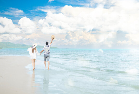 Couple holding hands running on the beach with vacation or holiday and happy for bonding, smiling and sea with honeymoon, fun and free.