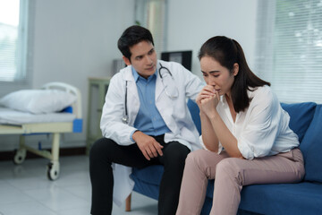 Doctor comforting sad patient in hospital room