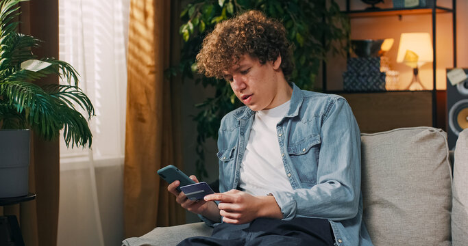 A determined student completes the last steps of an online transaction, entering his card number into a smartphone to pay for an English course he wants to start as soon as possible.