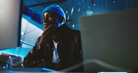 Black man, hacker and thinking with computer at night for programming, cyber attack and virus...
