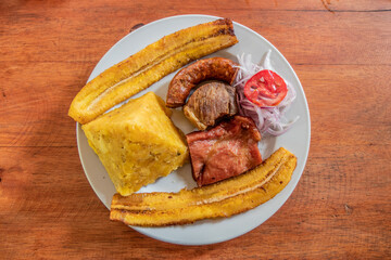 Typical meal of Peruvian Amazon - Tacacho mixto. It consists of chicharon (fried pork), cecina (cured pork), chorizo (sausage), mashed plantains and fried bananas.