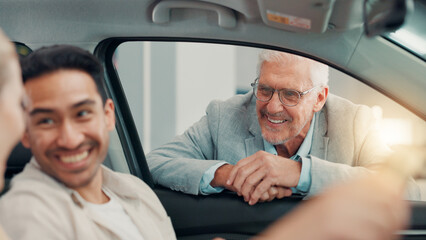 Drive, salesman and couple with laughing in car dealership, transport model and rental service. Showroom, people and mature seller with pitch for vehicle features, assistance and discussion by flare