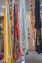 A variety of colorful beaded necklaces and prayer beads displayed for sale at a traditional market in Ras Al Khaimah, United Arab Emirates