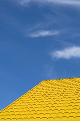 Bright yellow roof of metal roofing against blue sky