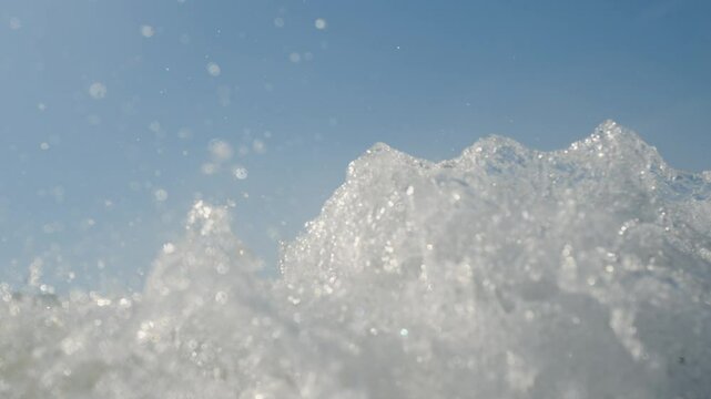 A body of water with a wave cresting in the foreground. The water appe