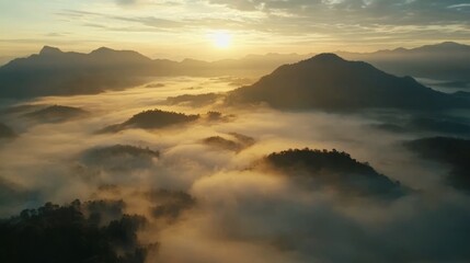 Obraz premium From above, a drone captures foggy mountains at sunrise in Phang Nga, Thailand. This wide view shows Southeast Asia's natural beauty. 