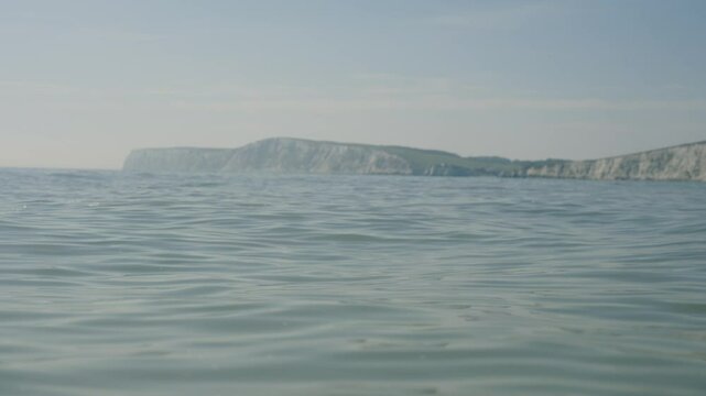 The ocean is calm and the sky is cloudy. The water is a deep blue colo