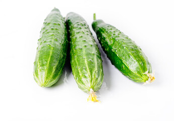 Three ground cucumbers on a white background. The concept of healthy eating