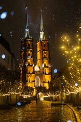 Naklejka premium old church in wroclaw poland in winter on a snowy night