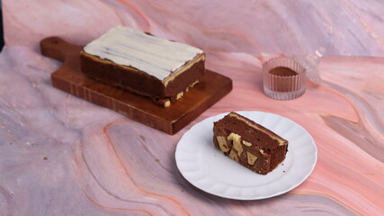 Kaasstengels or often called Cheese Shortbread in the photo with a wooden coaster and white plate. Cheese Shortbread pieces in the photo with a close up and a 45 degree angle