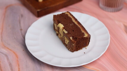 Kaasstengels or often called Cheese Shortbread in the photo with a wooden coaster and white plate. Cheese Shortbread pieces in the photo with a close up and a 45 degree angle