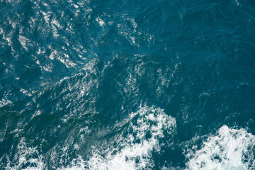 Aerial View of Ocean Waves with Shimmering Surface and Deep Blue Water Texture