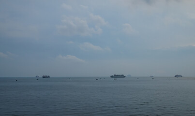Calm Seascape with Boats at Horizon Under Cloudy Sky in a Peaceful Marine Environment