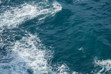 Vibrant Blue Ocean Waves with Seafoam Creating Dynamic Patterns in the Water Surface