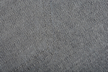 A close-up shows the textured underside of denim fabric with a diagonal twill pattern in shades of...