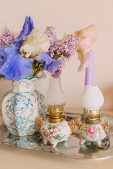 Elegant floral arrangement with antique oil lamps and pastel colors