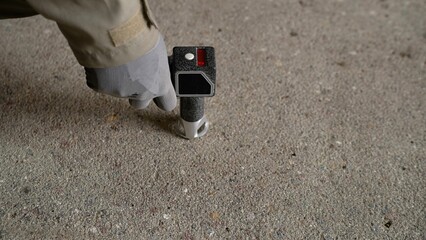 Technician measuring concrete floor density with electronic device