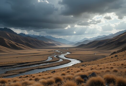 Expansive mountain valley with winding river under dramatic cloudy sky and sunlight rays