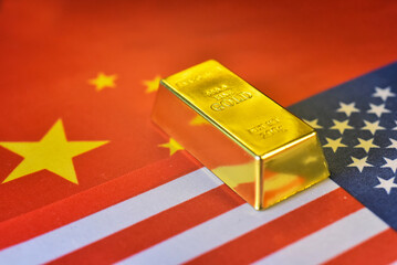Gold bar on US flag and China flag background. Gold is hard commodity goods, risk asset, tangible valuesave assets during war and economic crisis from trade war and reciprocal tariffs.