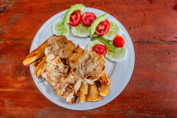 Dish in peruvian amazon - caiman fillet with fried cassava and salad