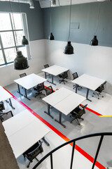 Modern office workspace featuring tables and chairs in a bright, minimalist design