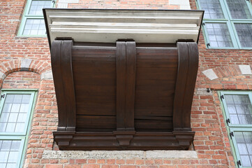 Wooden balcony on a brick wall