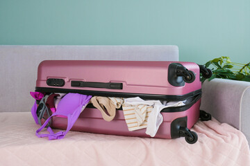 A suitcase with belongings a lot of clothes on the trip.