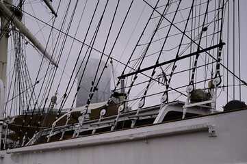 Sailboat rigging and the skyscraper in the fog