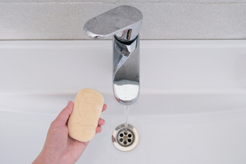 A woman washes her hands with soap and hair