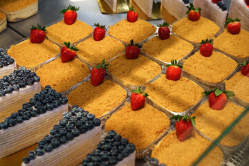 Delicious dessert display featuring strawberry and blueberry cakes in a bakery