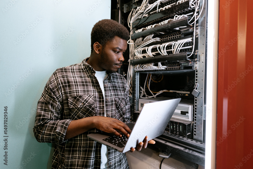 Poster technician configuring server settings in a data center during the day