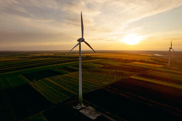 Aerial view of windmill turbines generating green energy electricity at sunset.Green energy helps reduce carbon emissions and makes the earth cleaner and more ecological.Ecology technology industrial.