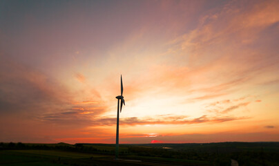 Obraz premium Green energy helps reduce carbon emissions and makes the earth cleaner and more ecological.Ecology technology industrial.Aerial view of windmill turbines generating green energy electricity at sunset.