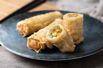 Crispy vegetable Spring Rolls on Ceramic Plate on wooden table