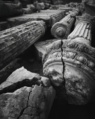 A wide-angle shot of fallen Roman columns, their majestic remains scattered across the landscape, evoking history and decay