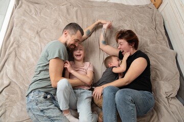 Smiling parents having fun with kids at home. Happy family moments