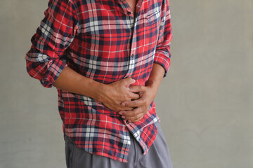 Asian man standing with severe stomach pain. Diarrhea. Emergency illness that requires hospitalization.