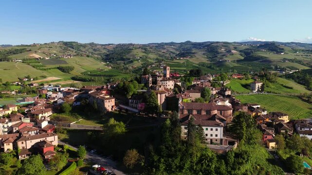 Drone orbits historic Neive, capturing terracotta roofs and ancient architecture of this Langhe wine region village as evening approaches, Piedmont, Italy. [19]