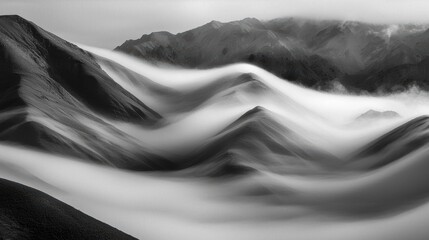 Black and white photograph of a mountainous landscape. the photograph is taken from a low angle, looking up at the mountains in the distance.